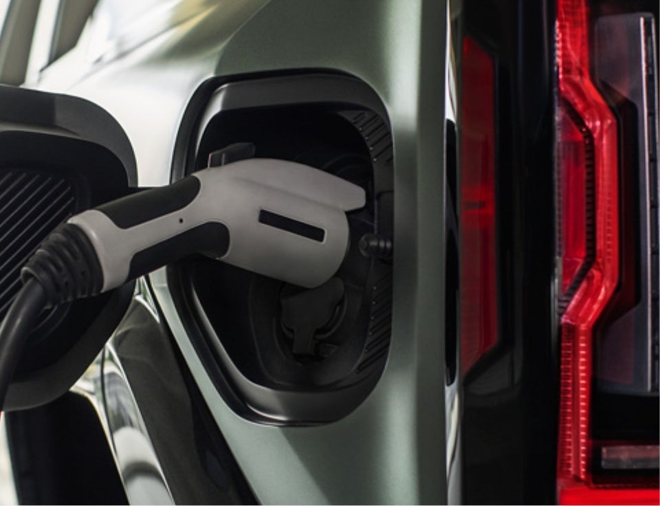 Close up of charging port with charger plugged in on a GMC Hummer EV SUV - Foy GMC in Many LA